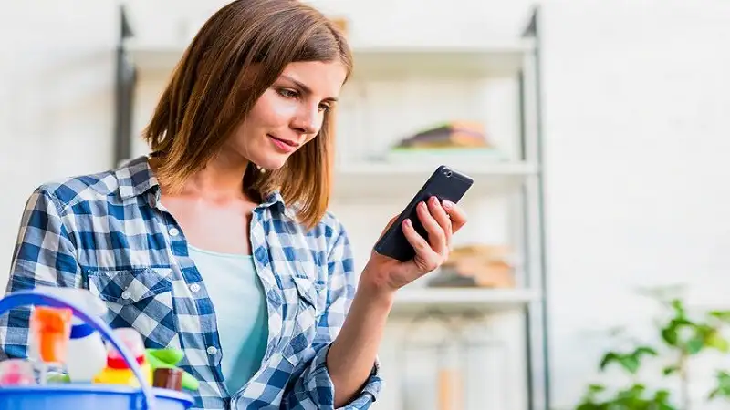 beth taps her phone at a payment terminal